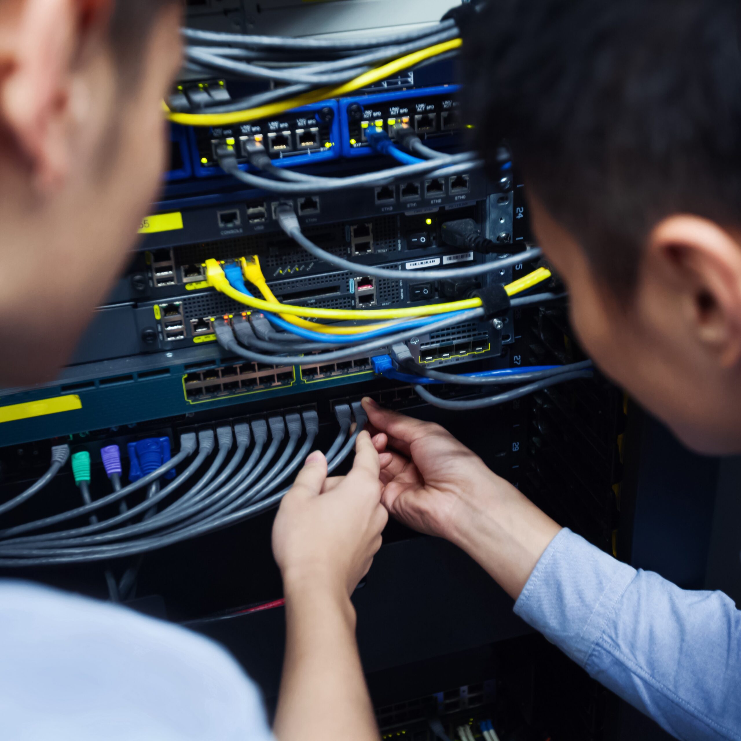 Joven ingeniero informático inspeccionando el cable de red.